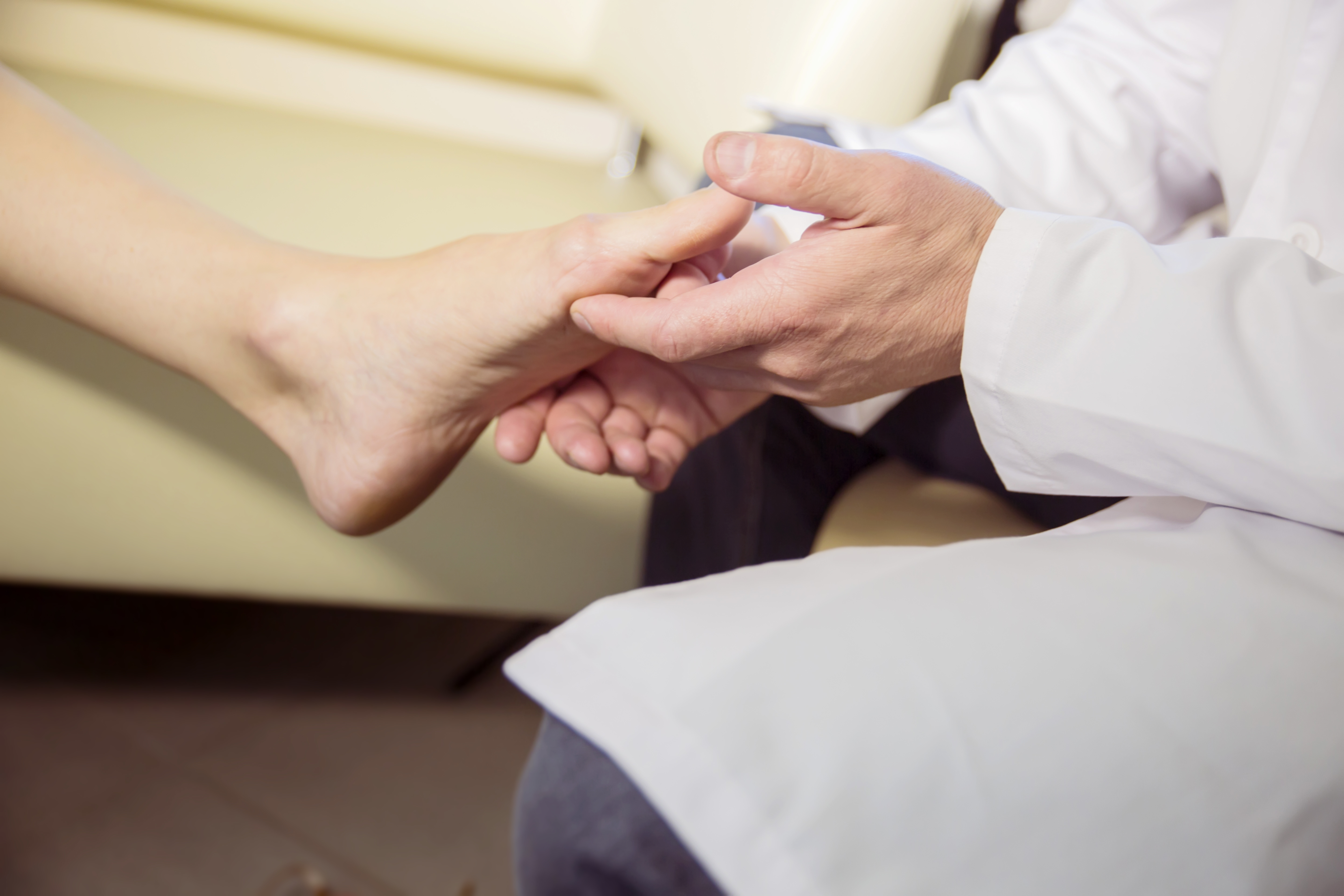 Photograph closeup of a podiatrist holding a patient's foot