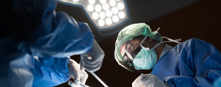 Photograph of podiatrist during surgery in an operating room
