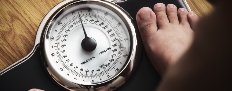 Photograph closeup scale while obese adult stands on it