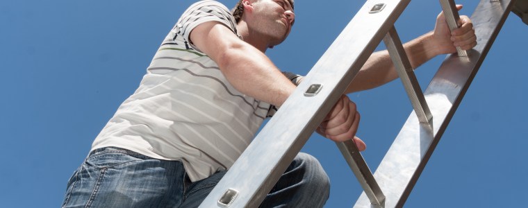 Photograph of man climbing a ladder