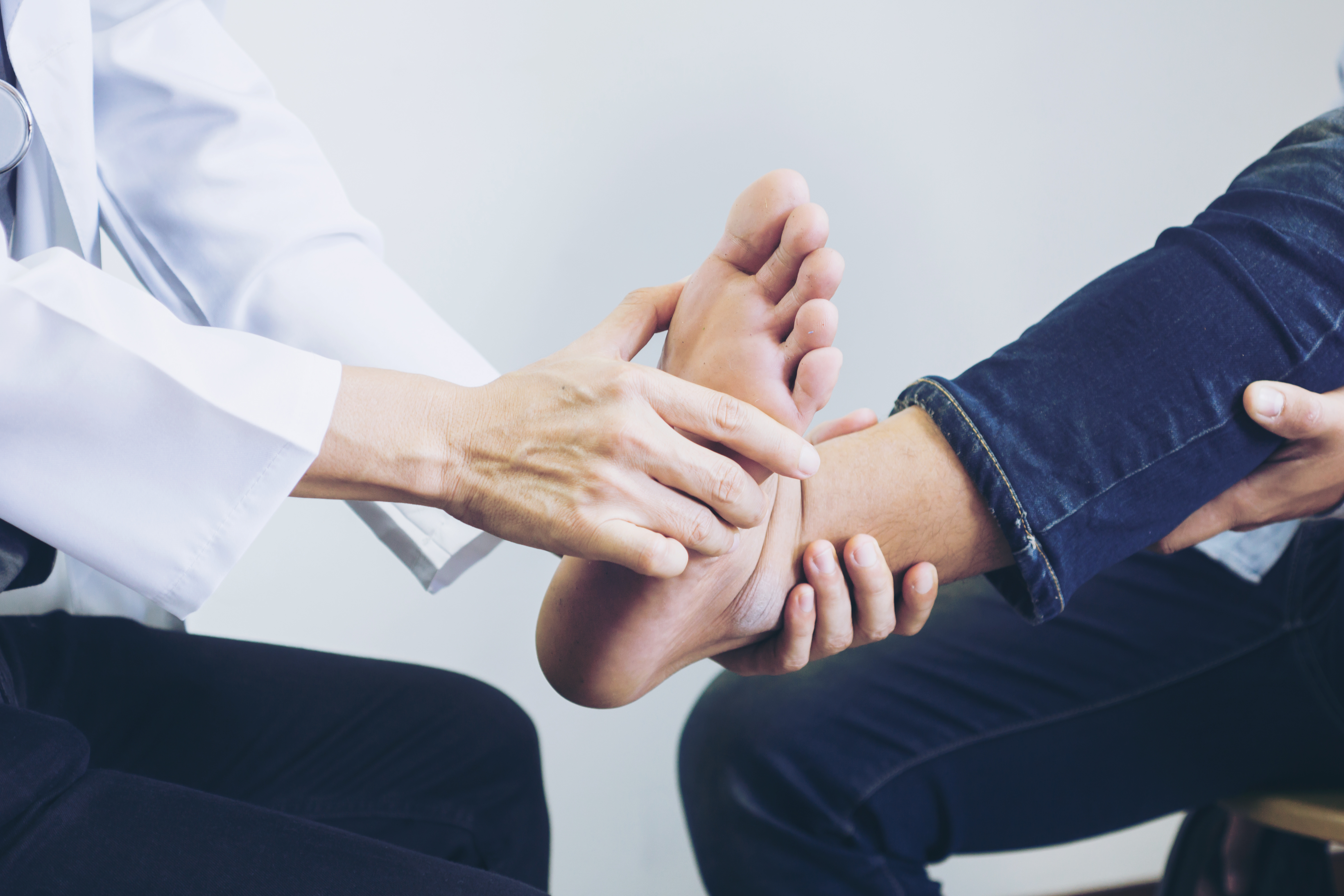 Photograph of podiatrist examining man's foot at the medical office