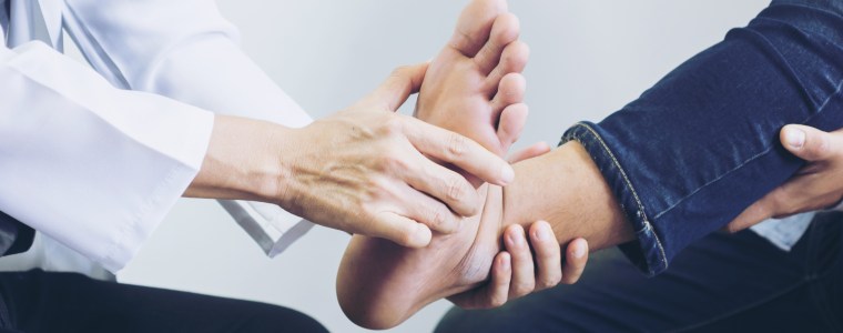 Photograph of podiatrist examining man's foot at the medical office