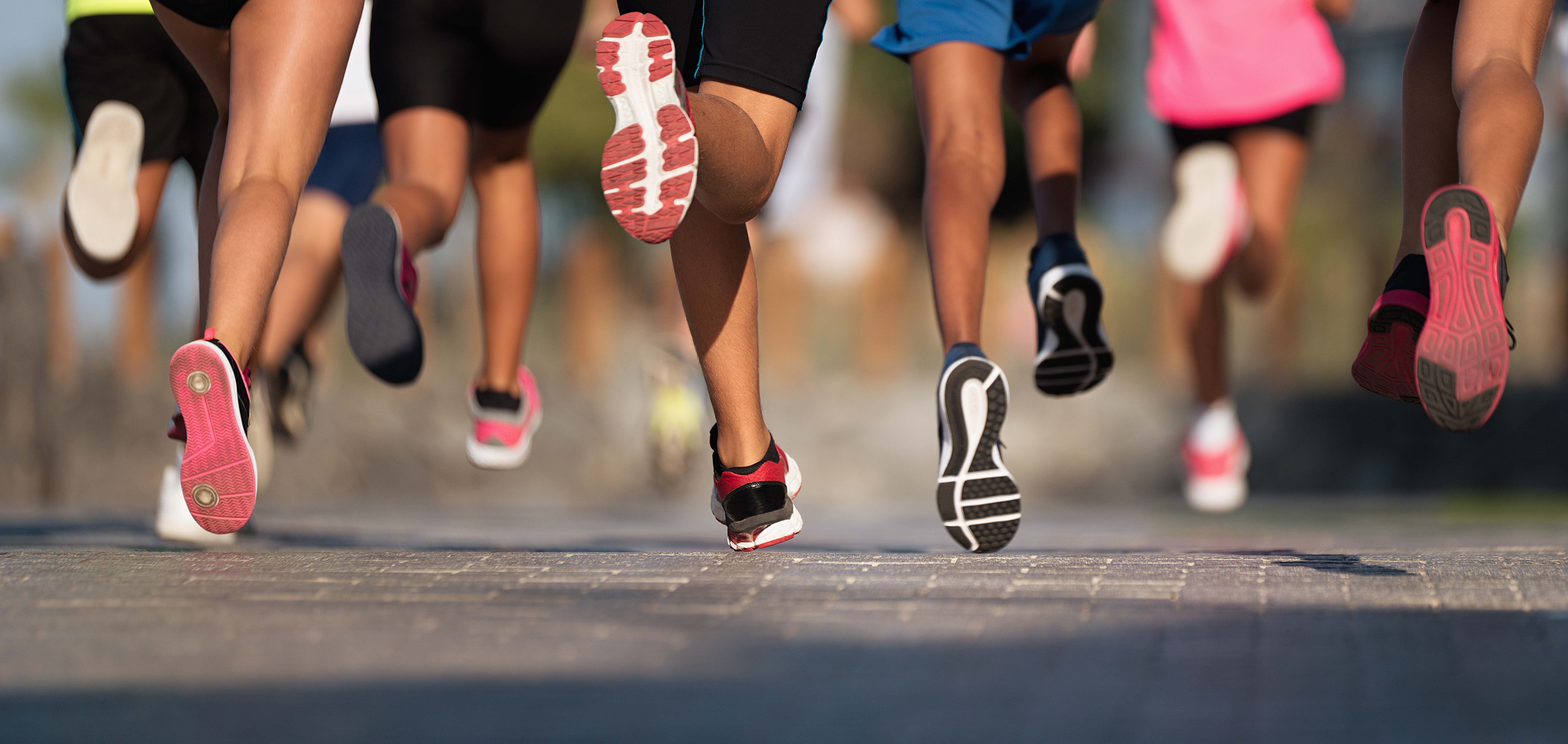 Photograph of legs, young athletes running a race