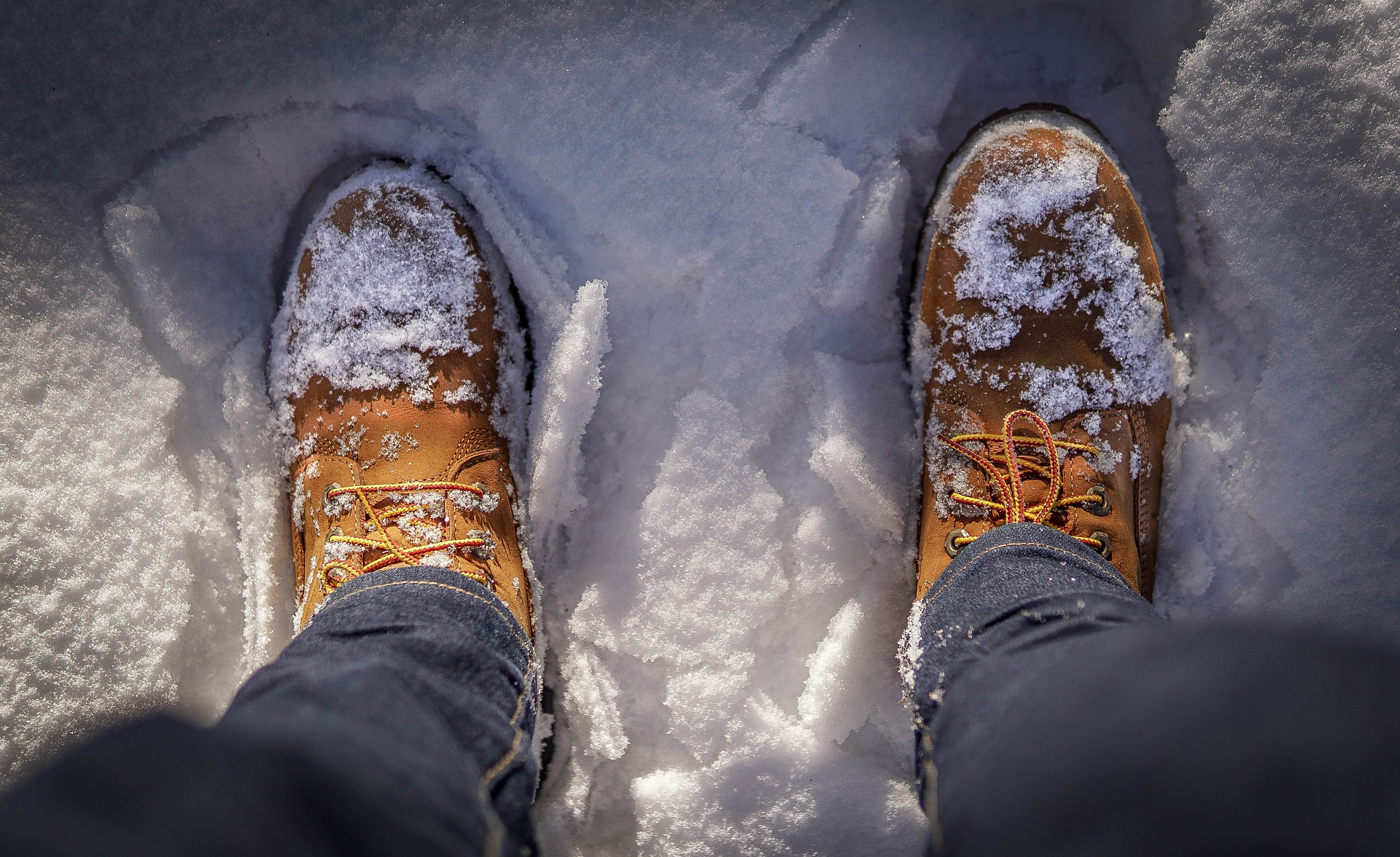Photograph of hiking boots while standing in snow.