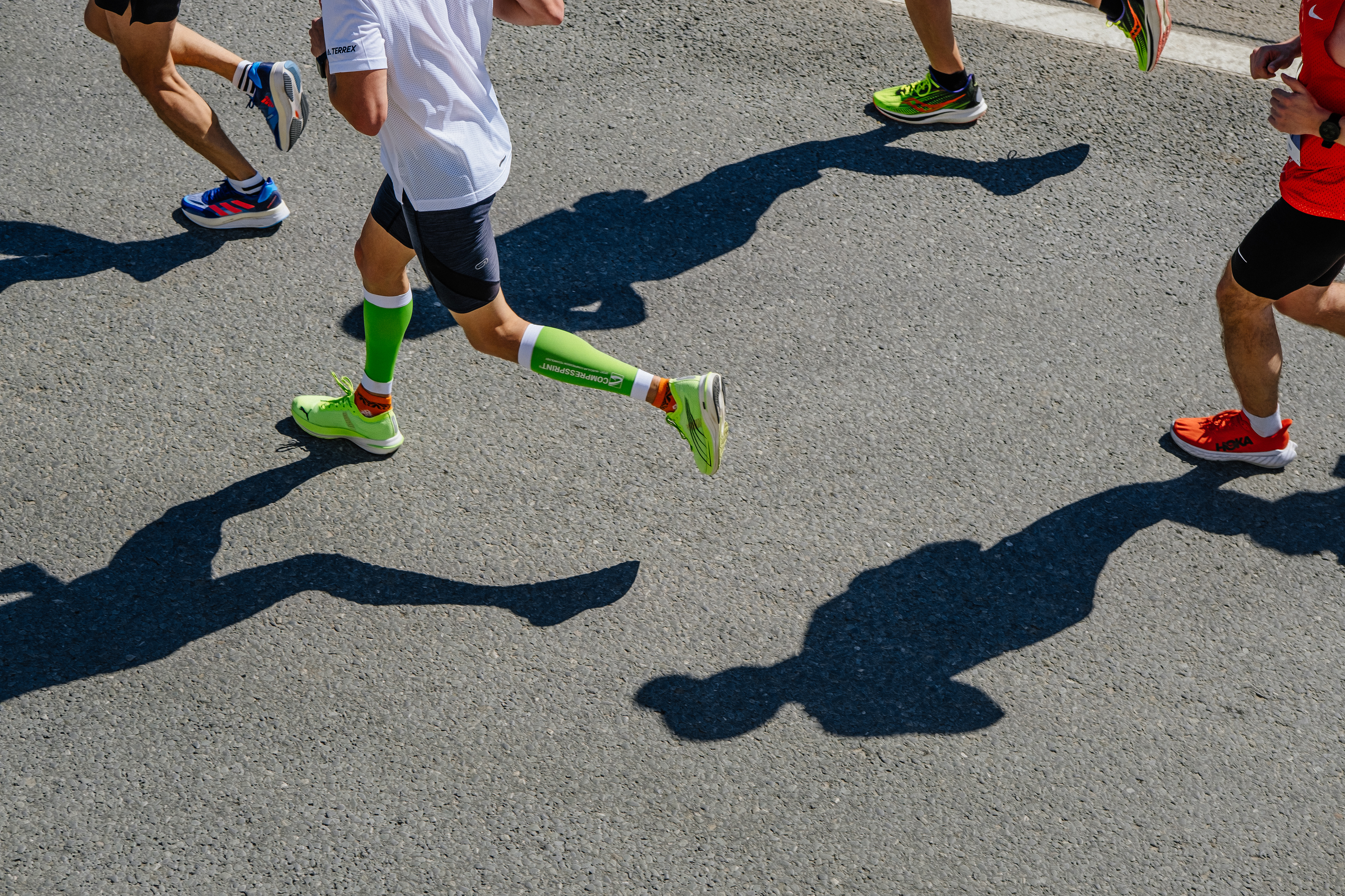 Legs of runner athlete in compression socks during a marathon.