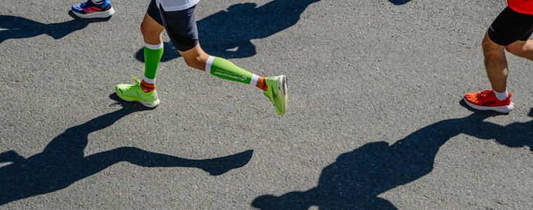 Legs of runner athlete in compression socks during a marathon.